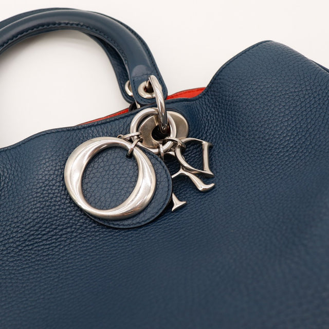 Détail breloque et charm Dior argenté sur Diorissimo bleu marine — AMANA Vintage