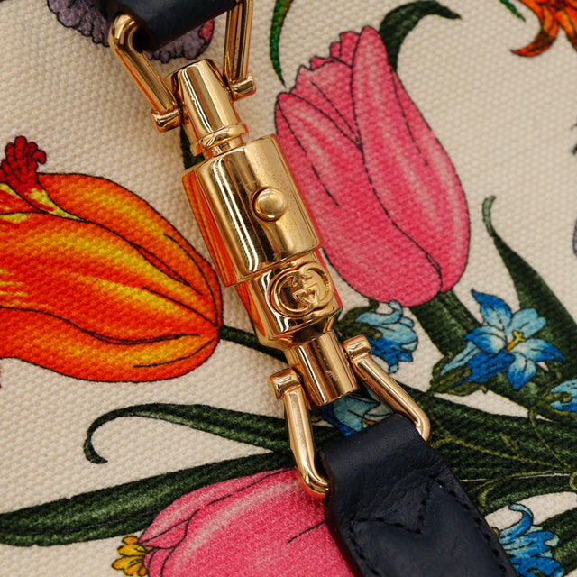 Détail fermoir piston doré Gucci Jackie Flora logo GG gravé — AMANA Vintage