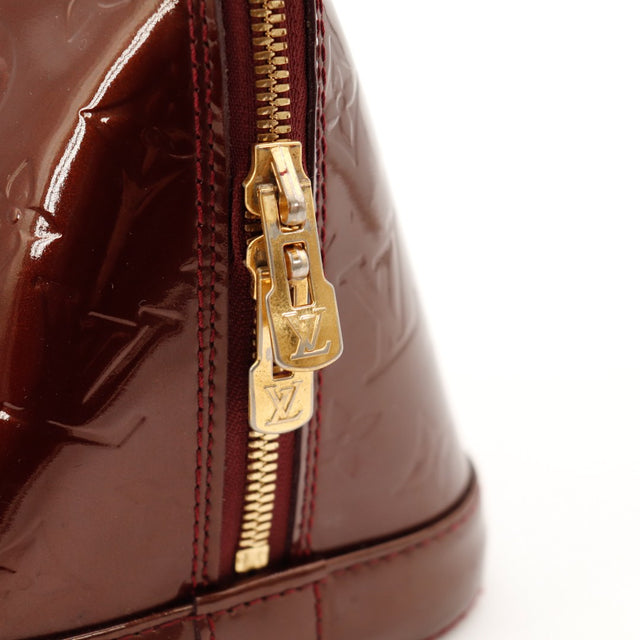 Détail curseur zip doré Louis Vuitton Alma PM Vernis Amarante — AMANA Vintage