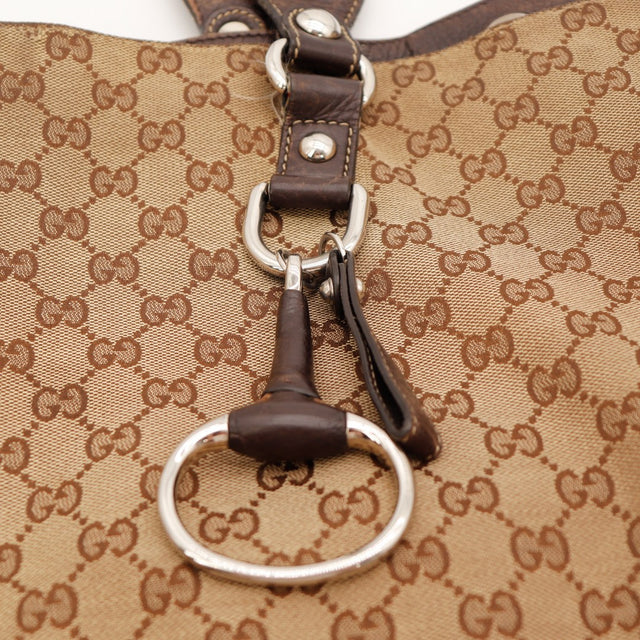 Détail breloque Horsebit Gucci cuir marron anneau argenté — AMANA Vintage