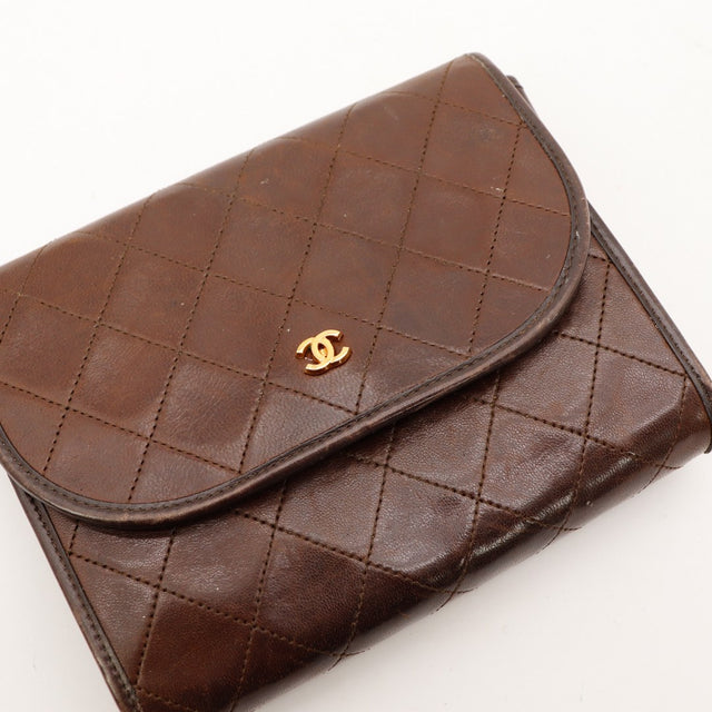 Détail cuir agneau matelassé Chanel brun avec logo CC doré gros plan — AMANA Vintage
