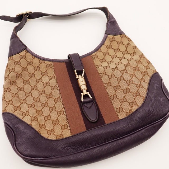 Détail fermoir piston doré signature Gucci Jackie toile monogrammée — AMANA Vintage