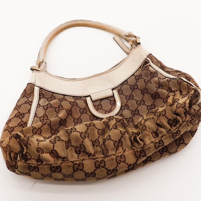 Détail cuir ivoire assombri et D-Ring Gucci doré vue rapprochée — AMANA Vintage