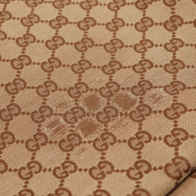 Détail macro toile monogrammée Gucci zone frottée — AMANA Vintage