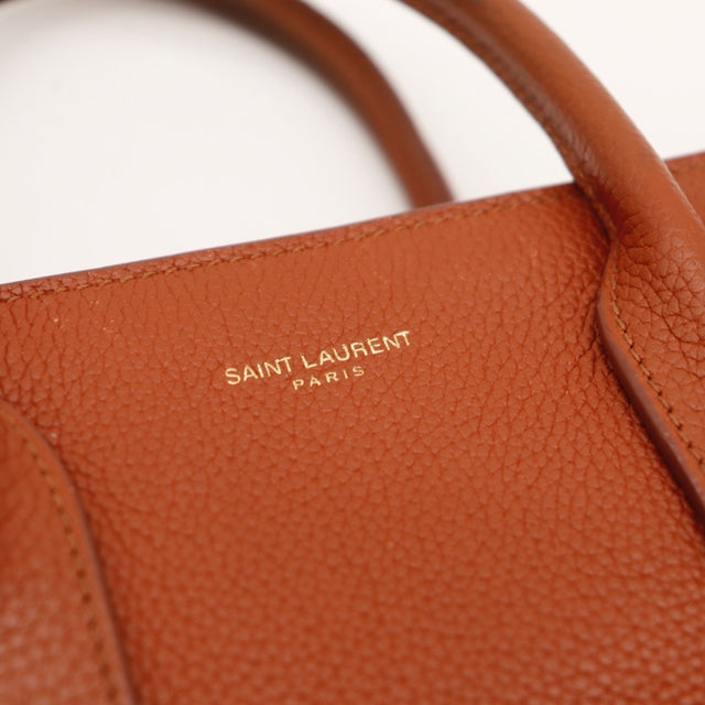 Détail de la patte latérale à pression Saint Laurent Baby Sac de Jour Souple cuir grainé cognac occasion authentique — AMANA Vintage