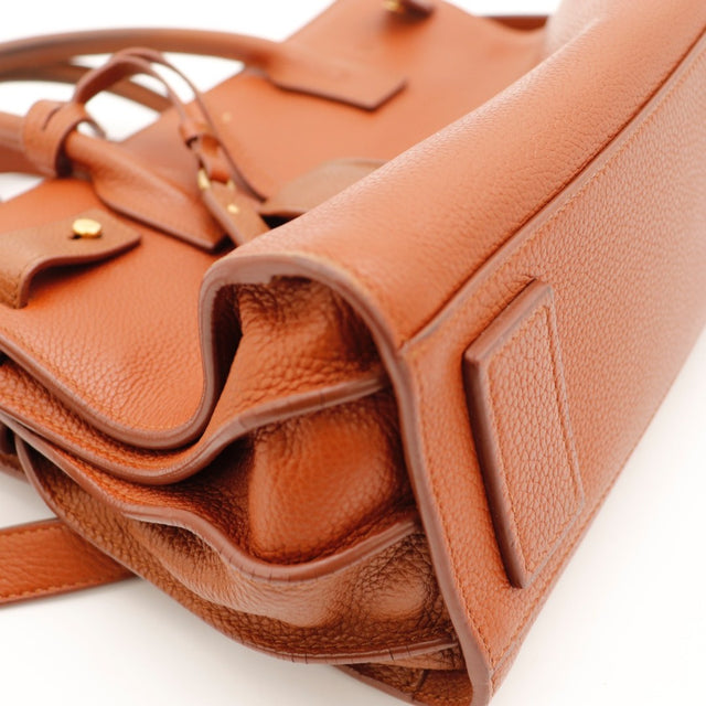 Détail de la clochette Saint Laurent Baby Sac de Jour Souple cuir grainé cognac occasion authentique — AMANA Vintage