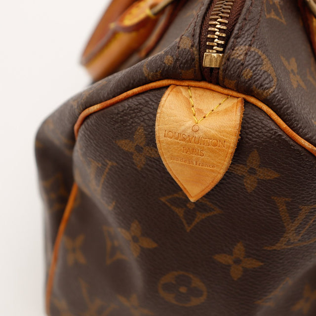 Détail anses et tabs vachette patine caramel Louis Vuitton Speedy 25 — AMANA Vintage