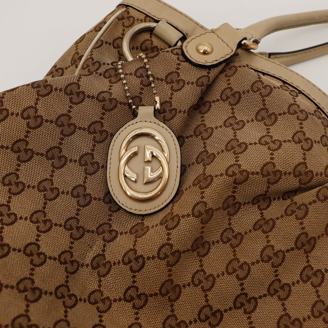 Détail breloque GG Gucci Sukey Tote cuir beige doré occasion — AMANA Vintage