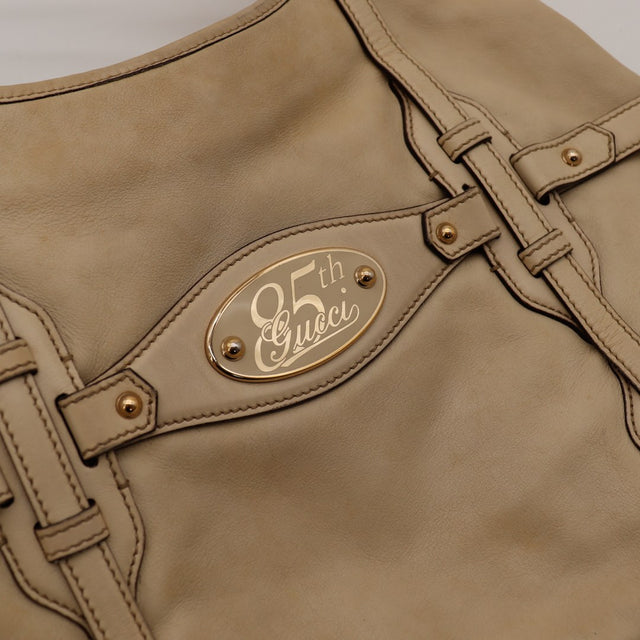 Détail plaque 85th Gucci Hobo Horsebit cuir beige occasion authentique — AMANA Vintage