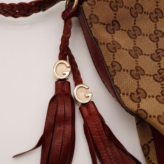 Détail pampilles cuir bordeaux et breloques G dorées Gucci Hobo occasion authentique — AMANA Vintage